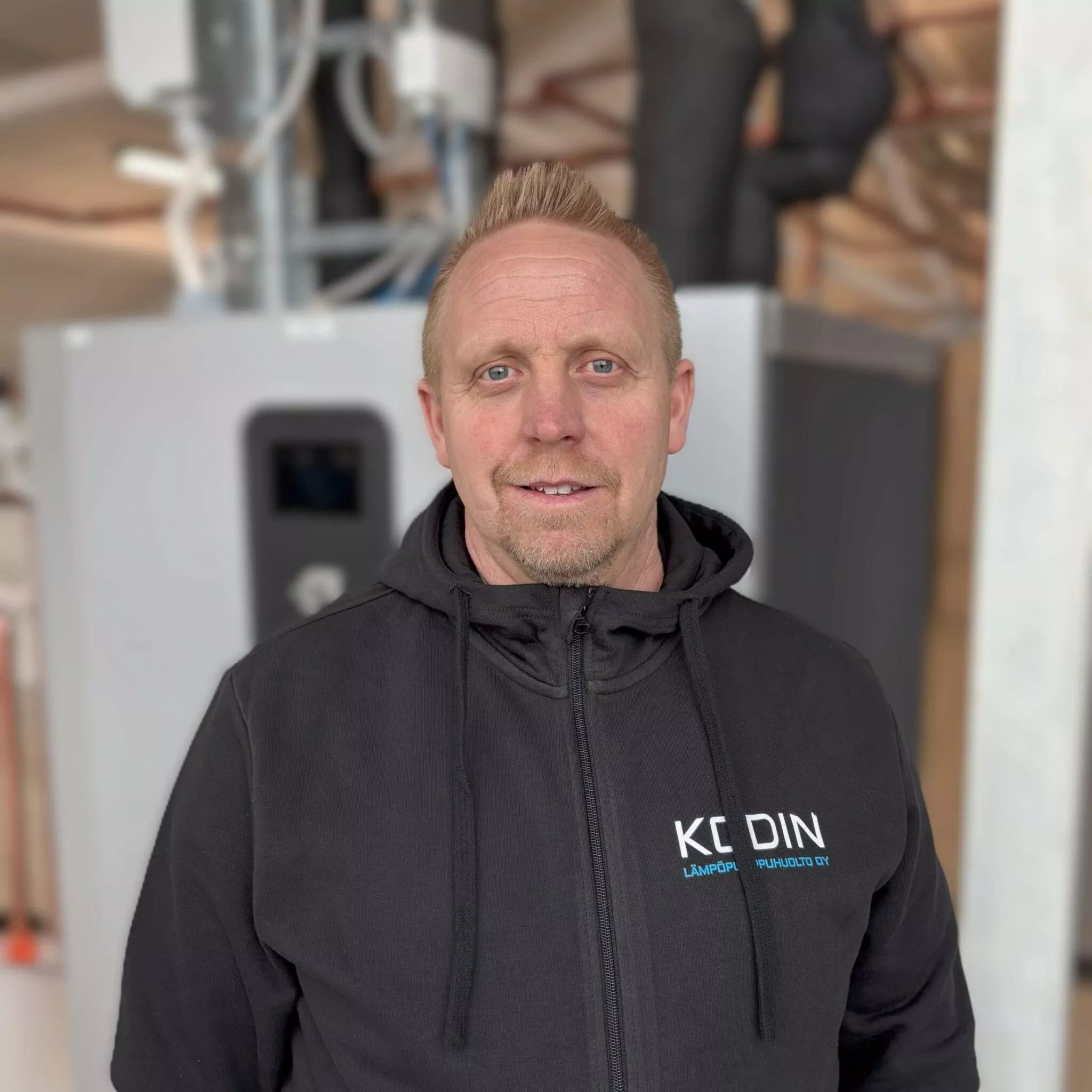 Erik, Vastuu Energian työntekijä, mustassa yrityksen hupparissa, teknisten laitteiden edessä