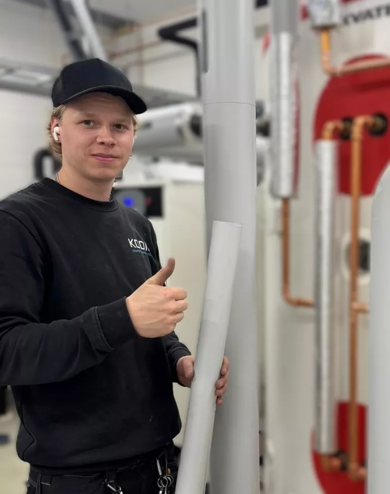 Vastuu Energian asentaja näyttää peukkua lämmityslaitteiston vieressä